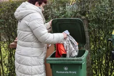 odlaganje oblačil v zabojnik za mešane odpadke / Foto: Tina Dokl