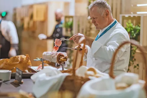 Priprava nekaterih jedi v živo pred gosti ali pa rezanje pršuta, kuhane oziroma pečene šunke v živo je zanimiva nadgradnja ponudbe jedi na tovrstnih dogodkih. / Foto: Arhiv Organizatorja