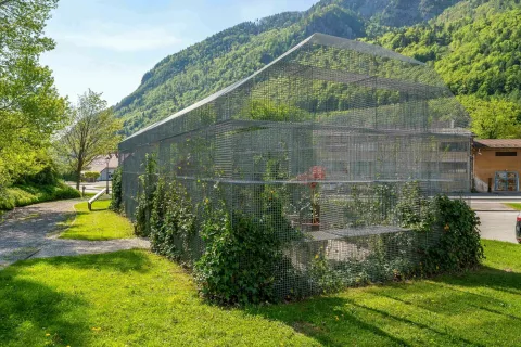 Sodobna konstrukcija iz kovinskih mrež, odeta v zelenje, ki ponazarja tloris nekdanje Korenove hiše / Foto: Nik Bertoncelj