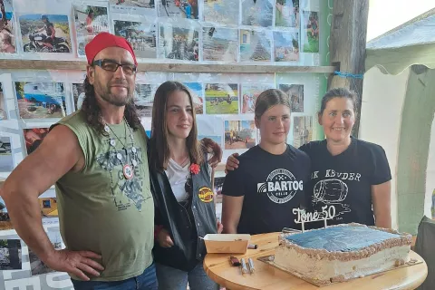 Tone z družino ob veliki praznični torti z napisom Tone 50 kot simbolom prehojene poti – pol stoletja izkušenj, dogodivščin in toplih odnosov. / Foto: Osebni Arhiv