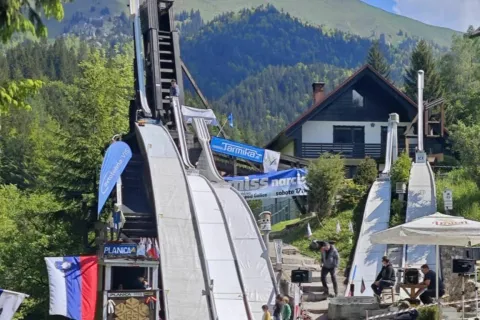 V pristnem planiškem vzdušju po maketi planiške skakalnice spuščajo figurice smučarskih skakalcev. / Foto: arhiv TD Golica