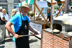 Na eni od stojnic na Pogačarjevem trgu se je predstavilo tudi TD Bled s posmoduljami. Posmodulja je gorenjska oblika pice z zaseko in ocvirki ali sirom in česnom. Za peko in postrežbo sta poskrbela vodja Vanja Piber in predsednik Zoran Pogačnik. / Foto: Peter Irman/tzs