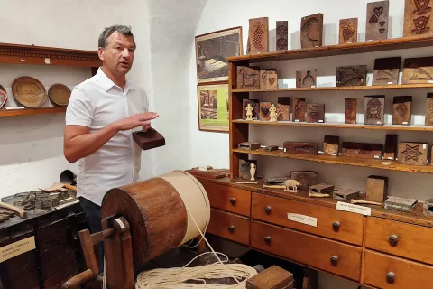 Janez Stele rad pojasni, kako so nastale Plečnikove sveče: »Plečnik je predlagal, naj v modele za lectova srca vlijejo čebelji vosek in ga odtisnejo na debele sveče.« / Foto: Katja Dolenc