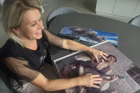 Jasna Križaj s fotografijo goslarja, ki so jo z reliefnim tiskom približali tudi slepim in slabovidnim. / Foto: Maja Bertoncelj