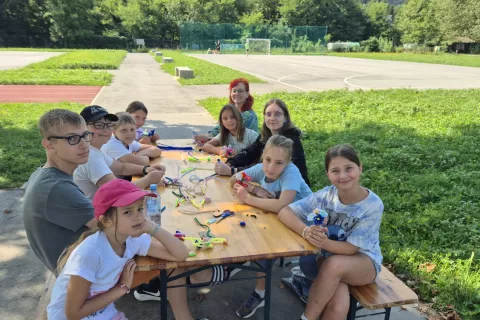 Izpod prstov udeleženk in udeležencev delavnice rožic iz kosmatenih žičk so nastajale čudovite rožice in šopki. / Foto: Klara Mrak