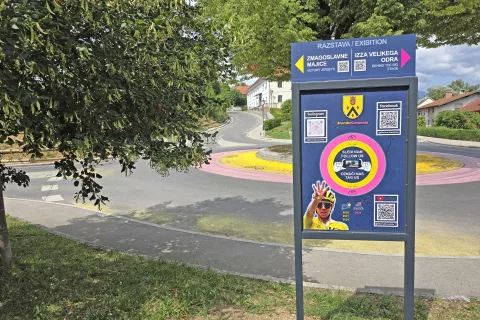 Nova usmerjevalna tabla ob občinski stavbi vabi na dve razstavi, v ozadju verjetno trenutno najbolj znan rondo v državi. / Foto: Špela Šimenc
