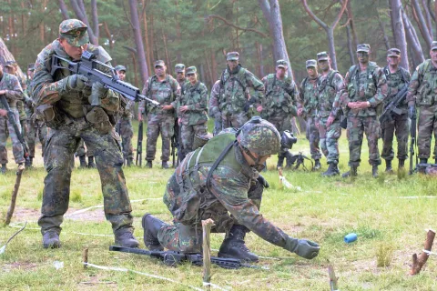 V kakšni formi je nemška vojska (Bundeswehr)? Na sliki iz leta 2004 sta nemška vojaka na vežbah, v ozadju ju opazujejo ameriški vojaki.  / Foto: Wikipedija
