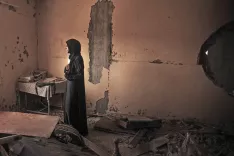 Fatima Asfour stoji sredi ruševin svojega stanovanja v Khan Younisu v Gazi. V rokah drži fotografiji svojih dveh sinov, ki sta septembra 2014 prebežala iz povojne Gaze. Oba, Ramez (26) in Ahmed (25), naj bi bila mrtva po potopitvi ladje ob obali Malte. Do danes še ni prejela nobenih uradnih novic o njuni usodi. Khan Younis, Gaza, 27. september 2014. / Foto: Matic Zorman