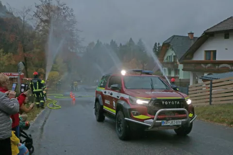 Večnamensko gasilsko vozilo so ob prihodu v kraj jezerski gasilci pospremili z močnim vodnim špalirjem. / Foto: Alenka Brun