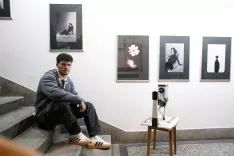 Fotograf Luka Detiček ob razstavljenih fotografijah, ki so v Galeriji Planika ustvarile intimno zgodbo o iskanju ravnovesja med egom in ljubeznijo. / Foto: Matic Zorman