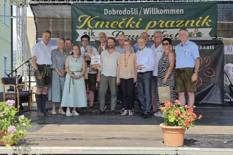 Organizatorji Kmečkega praznika, slovenski predstavniki v Koro&scaron;ki kmetijski zbornici, prejemniki priznanj na Ptuju in gostje na prireditvenem odru leto&scaron;njega praznika v &Scaron;entjanžu. Četrta z leve glavna organizatorka Marinka Mader Tschertou. / Foto: Jože Ko&scaron;njek