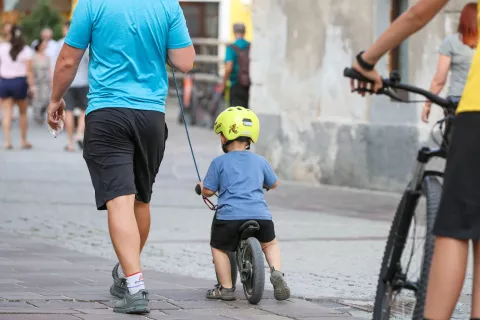 simbolična fotografija otro&scaron;ko kolo otrok stiska čelada varnost družina otrok poganjalec poganjalček otrok na vrvici / Foto: Tina Dokl