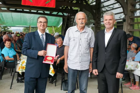 Predsednik Pokrajinske zveze društev upokojencev Gorenjske Ivo Veger (v sredini) je Vladimirju Koračinu (levo) ob jubileju izročil veliko plaketo Zveze društev upokojencev Slovenije. Ob njima župan Milan Čadež. / Foto: Tina Dokl