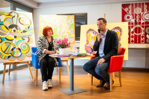 Domen Rakovec v pogovoru z Vlasto Nussdorfer, zadaj podarjene slike / Foto: Primož Pičulin