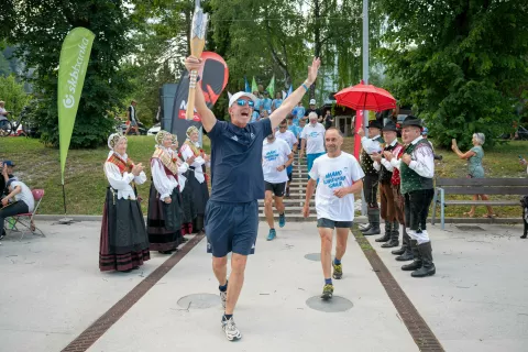 Takole veselo je baklo na Trg olimpijcev prinesel njen ambasador Jani Klemenčič, desno na sliki pa je Rajko Lotrič iz GRS Mojstrana. / Foto: Nik Bertoncelj