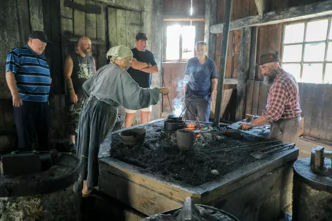 V vigenjcu Vice so obiskovalci z zanimanjem opazovali Sebastjana Lombarja pri kovanju žebljev. / Foto: Tina Dokl