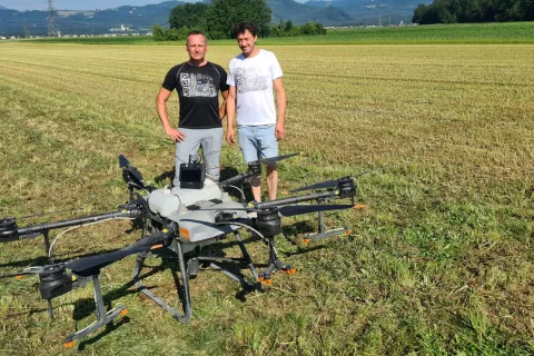 Borut Sovič in Grega Drinovec ob dronu, ki ga na Drinovčevi kmetiji že uporabljajo za foliarno gnojenje. / Foto: Cveto Zaplotnik