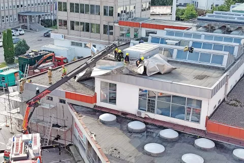 Močan sunek vetra je pločevinasto streho z večstanovanjske stavbe na Nazorjevi ulici v Kranju odpihnil na bližnji supermarket Spar. / Foto: Edo Hajdinjak / Foto: 