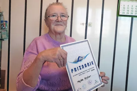 Majda Gričar s priznanjem za hrabro novoletno plavanje v ledeni Savinji / Foto: 